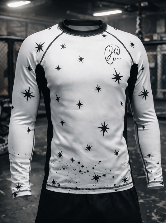 White long-sleeve shirt with black star patterns and a signature on a blurred background
